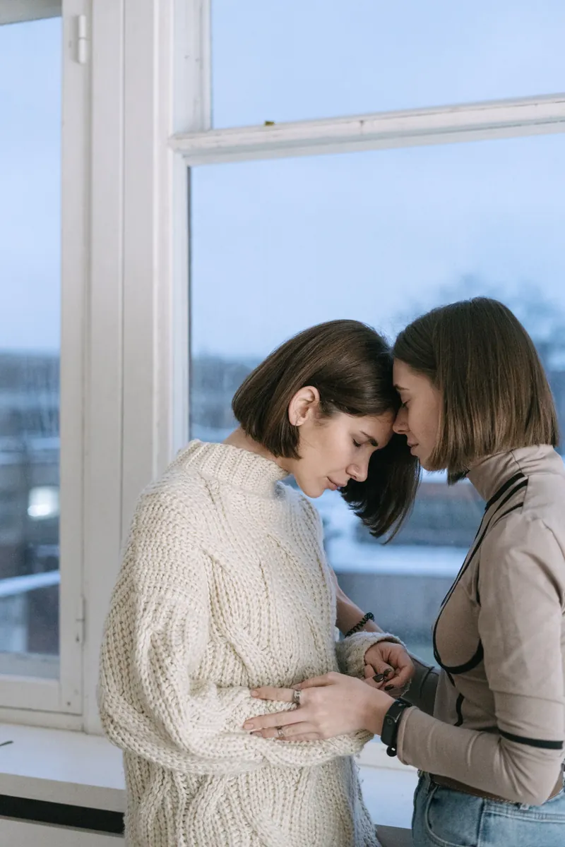 Zwei Frauen halten einander die Hände und geben sich Halt